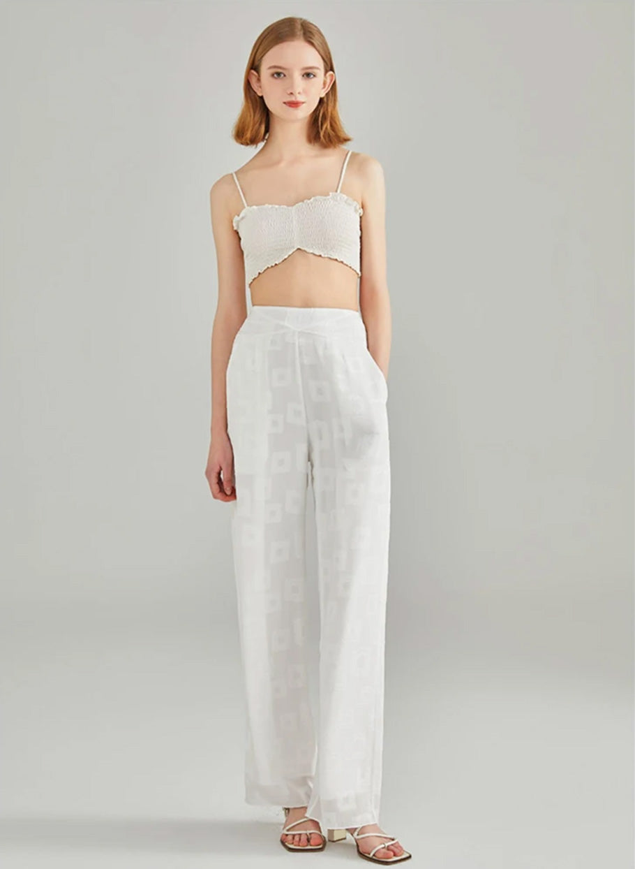 Model resting hand inside the functional side slash pocket of white Mulberry silk georgette trousers — From Borcelleclothes.