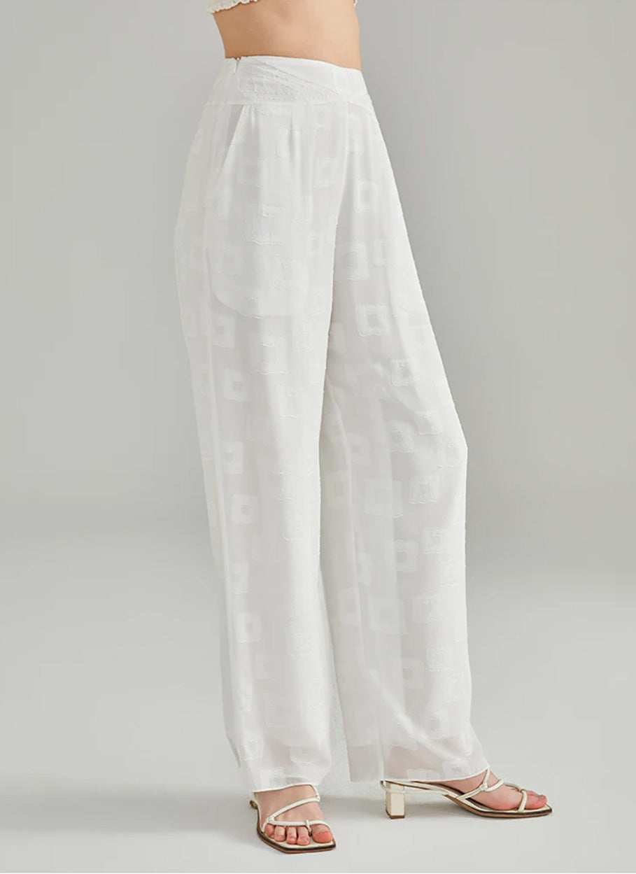 Right side-angle profile of a model wearing high-rise straight-leg white silk jacquard trousers — From Borcelleclothes.