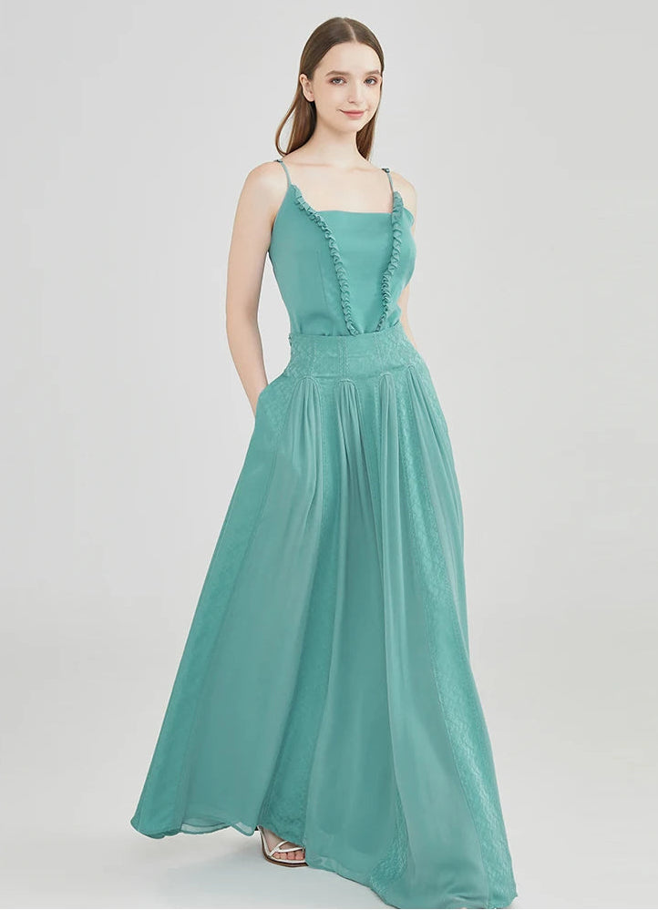 A walking shot of the model with hands behind her back, captured as the voluminous aqua-mint silk hem sweeps forward — From Borcelleclothes.