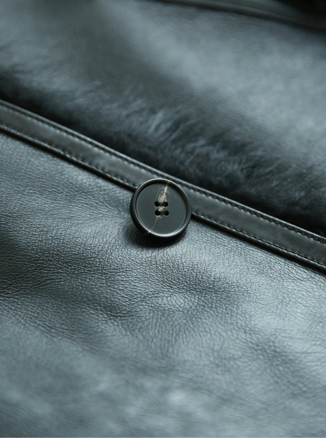 Detail of the button and leather surface on the Autographe shearling jacket — From Borcelleclothes.