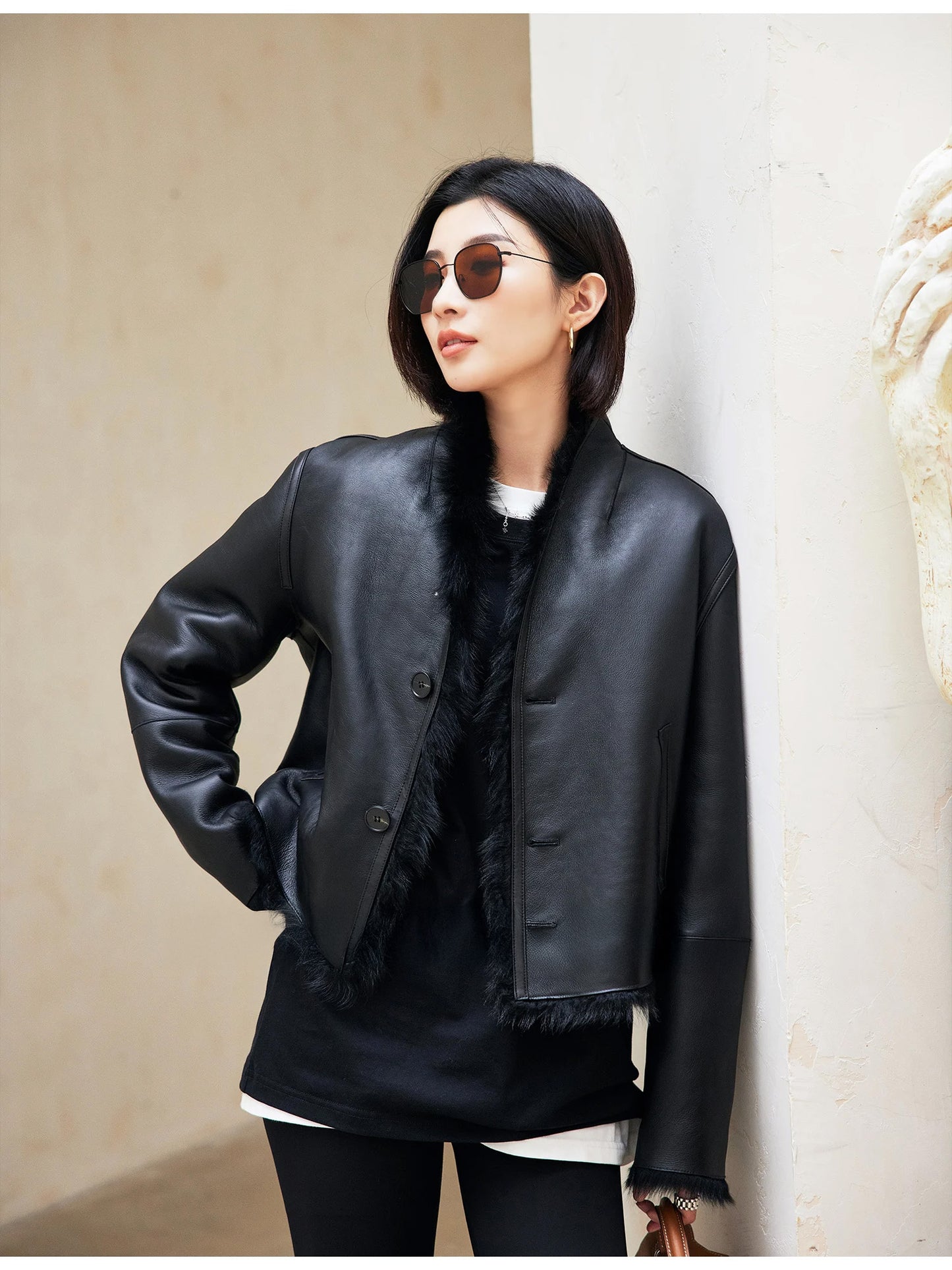 Model’s hand at the waistline of the Autographe jacket, leather side worn outward — From Borcelleclothes.