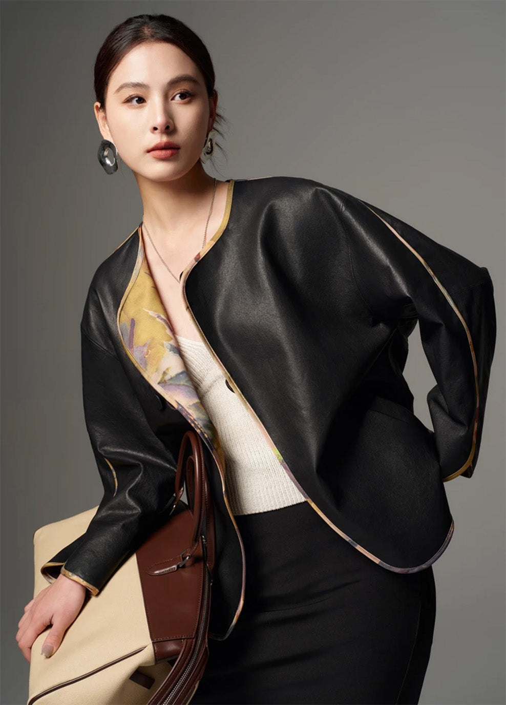 Model posed in profile showcasing the fluid drape of the reversible Nappa leather kimono jacket — From Borcelleclothes.