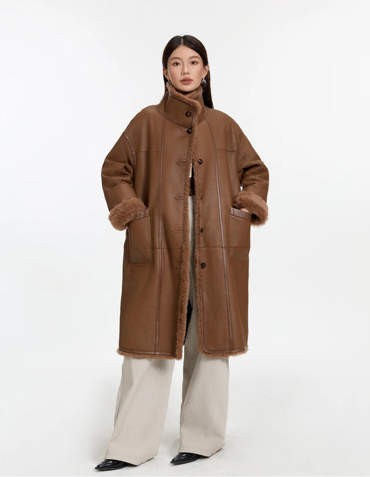Model wearing the Cedar Resin reversible shearling coat, hands in pockets, leather side out — From Borcelleclothes.