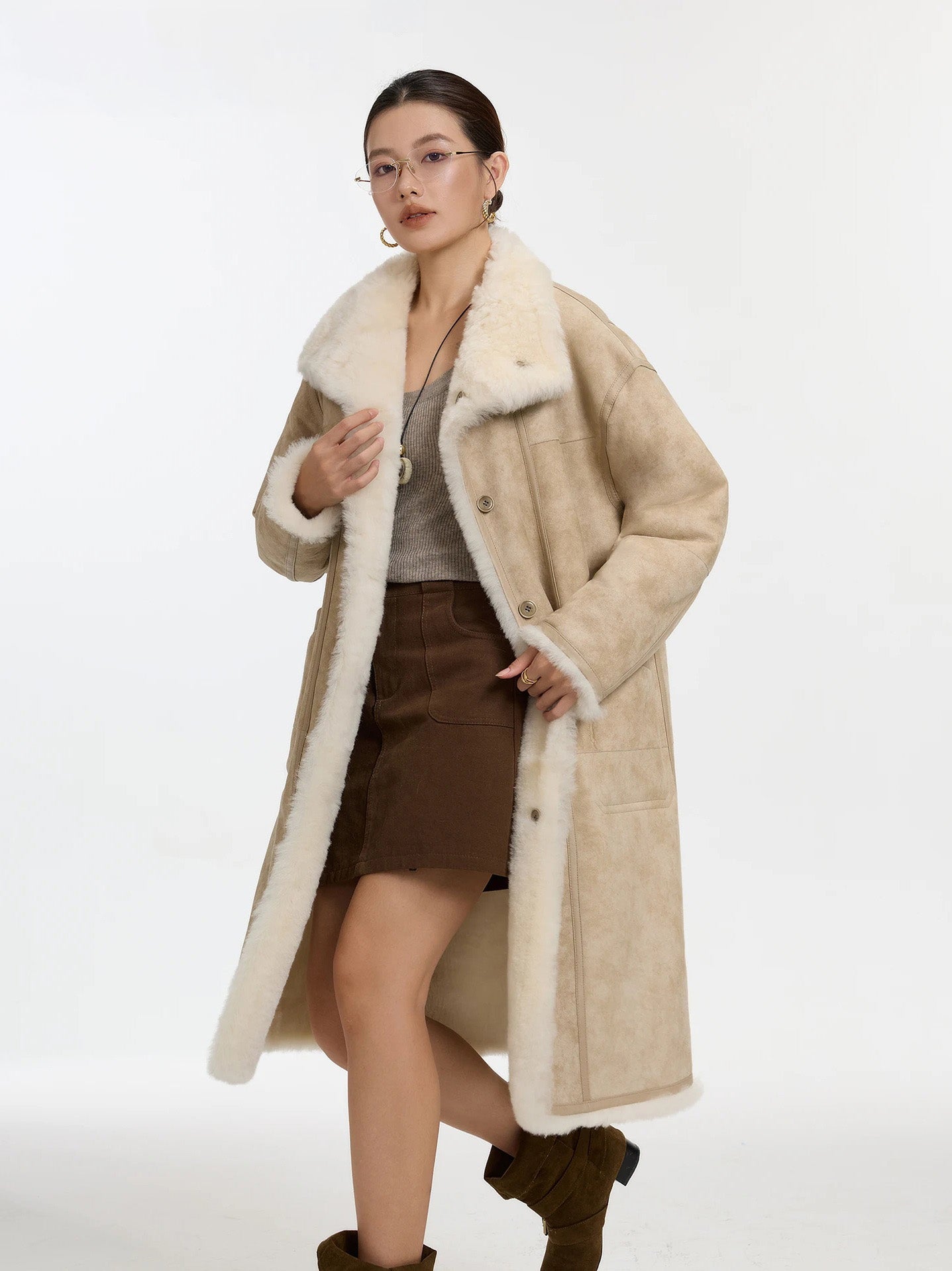 Side walking view of model in Oatmeal Wax shearling coat, leather side out — From Borcelleclothes.