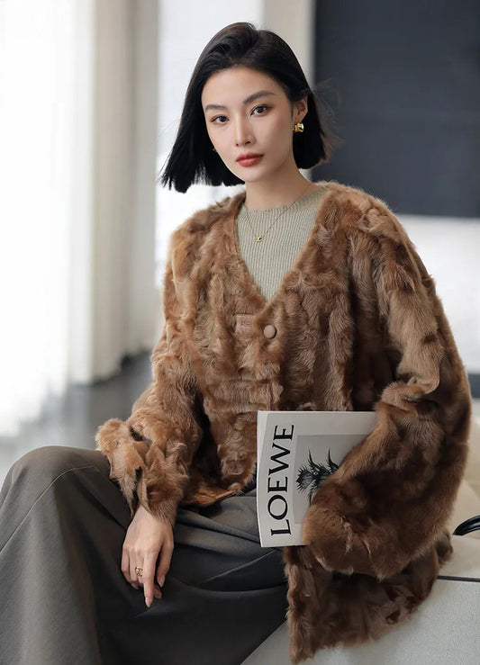 Women's reversible shearling jacket in Cinnamon Flame, featuring an arched hem, leather-wrapped buttons, and a textured unshorn wool surface — From Borcelleclothes.