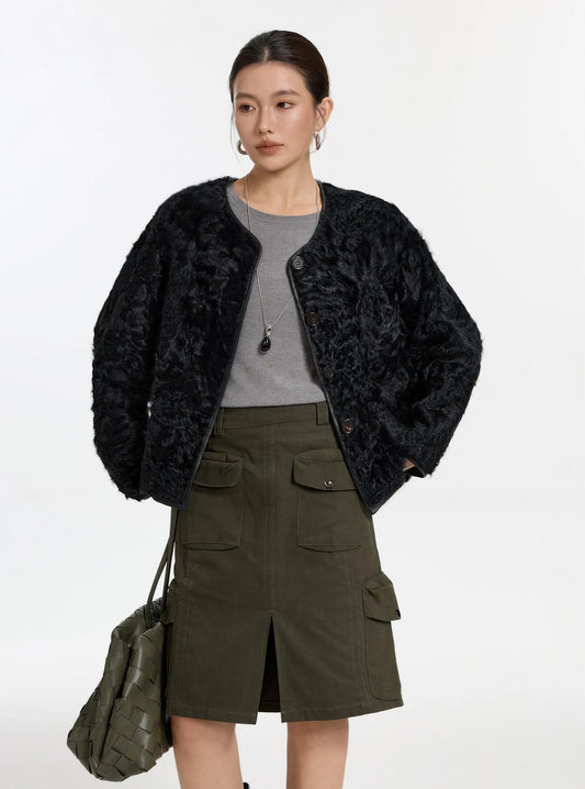 Women’s reversible shearling jacket with horn buttons in Blackjack, model with hands behind back, fur side — From Borcelleclothes.