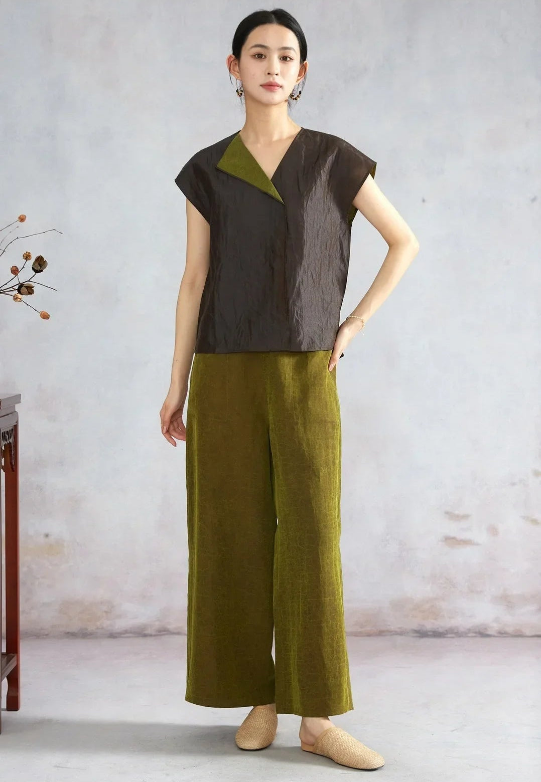 Woman with hand on hip showing a black reversible silk top — From Borcelleclothes.