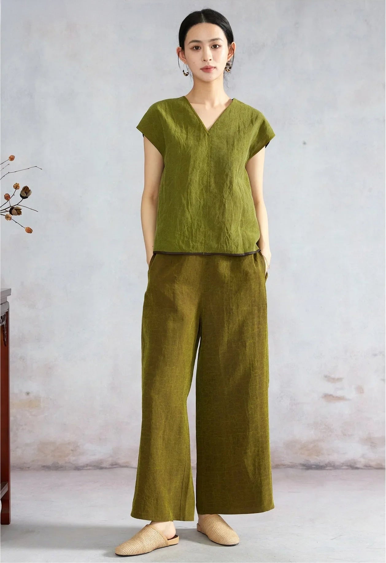 Woman posing in an olive reversible silk top with hands in pockets — From Borcelleclothes.