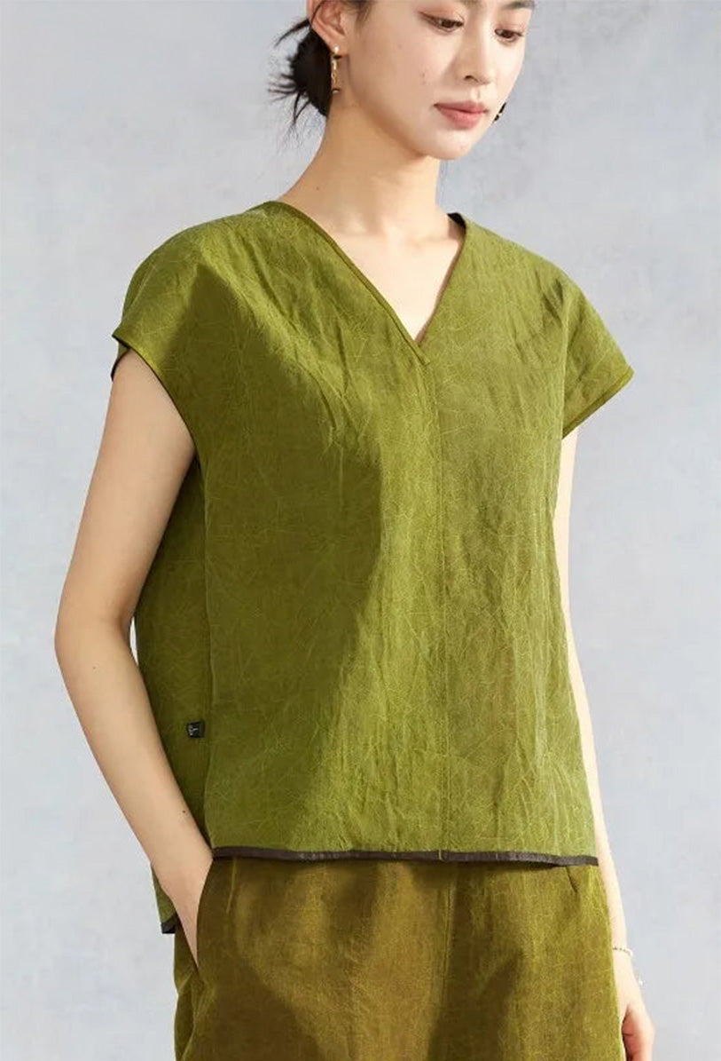 Woman looking to the side wearing an olive Xiangyunsha silk top — From Borcelleclothes.