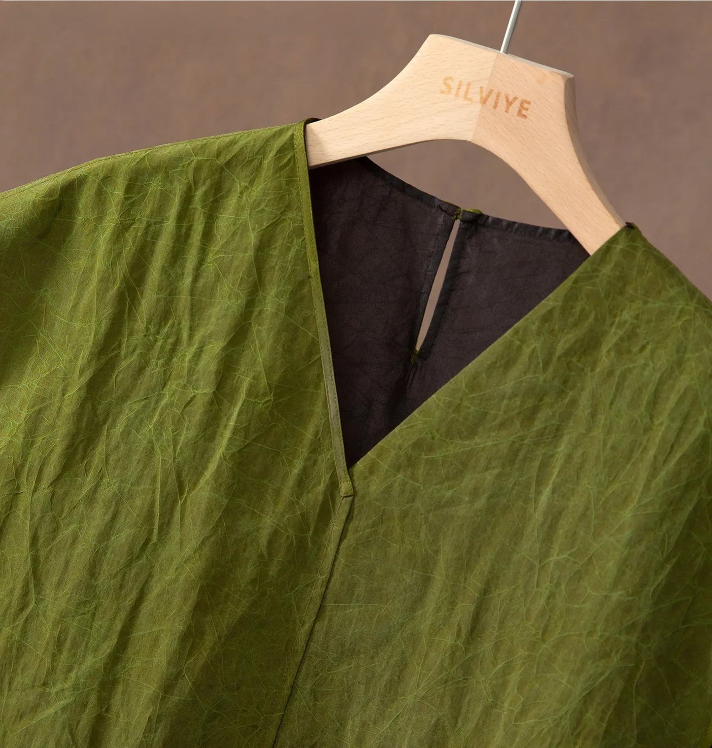 Detail of the V-neckline on an olive Xiangyunsha Mulberry silk top — From Borcelleclothes.