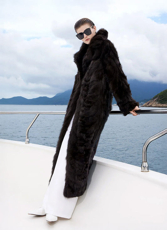 Model holding the yacht railing behind her in a full-length sable fur coat in Nevermore. — From Borcelleclothes.