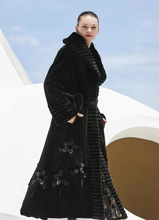 Women's sculpted mink coat in Nocturne with architectural ridged shawl collar, floral leather appliqué at the hem, and decorative brooch — From Borcelleclothes.
