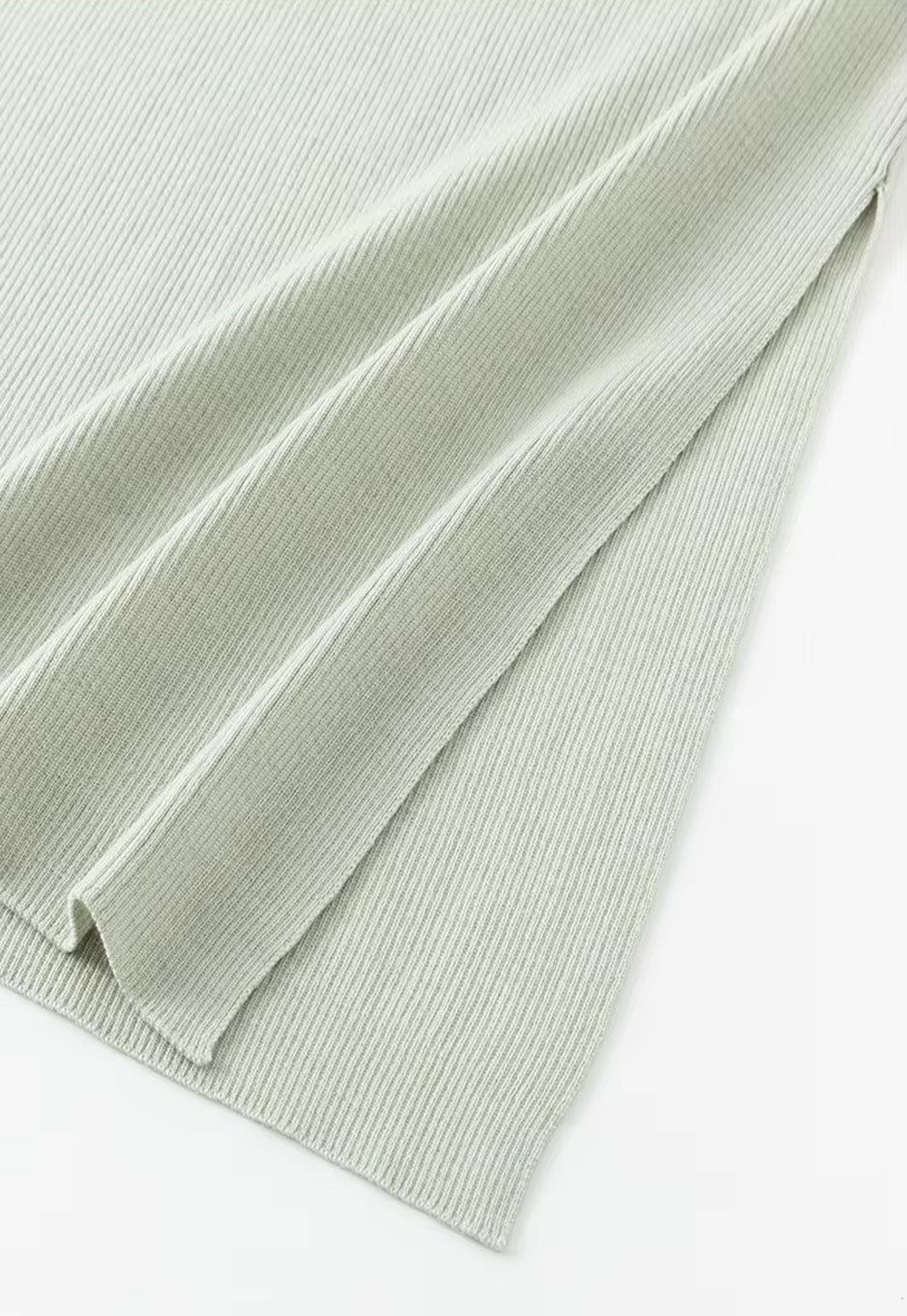 Detail shot of the discreet left-side slit on the straight silhouette wool-silk skirt in Compliant Sage green. From Borcelleclothes.