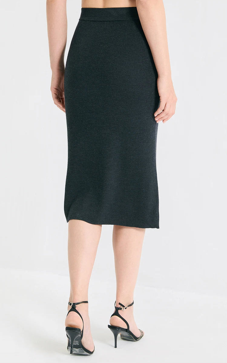 Back view of the sculptural 1x1 rib knit midi wool-silk skirt in Silent Adept black, showing its flawless fit. From Borcelleclothes.