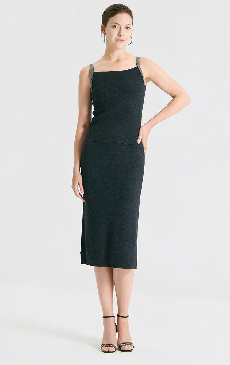 Full-height view of a model standing with a hand on her hip, wearing the straight silhouette wool-silk skirt in Silent Adept black. From Borcelleclothes.