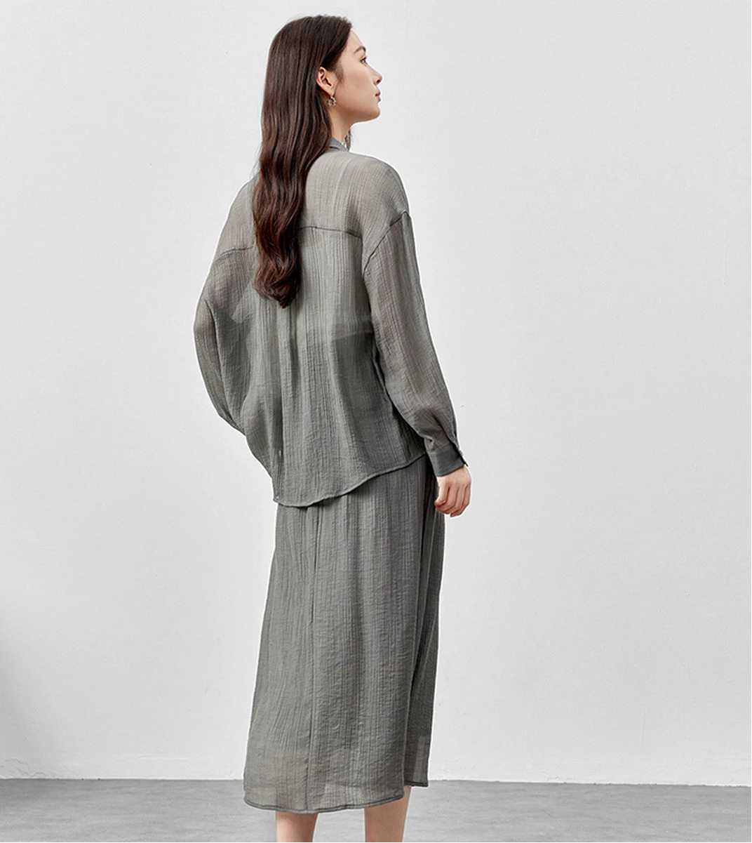 Rear view of a woman wearing a semi-sheer graphite rain lyocell two-piece set. — From Borcelleclothes.