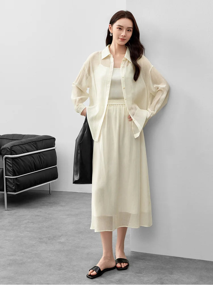 A woman holding a black bag with hands on her hips wearing a pollen flight lyocell set. — From Borcelleclothes.