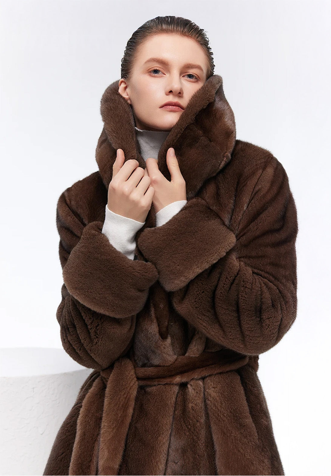 Model holding raised collar of Eclipse shawl-collared mink coat — From Borcelleclothes.