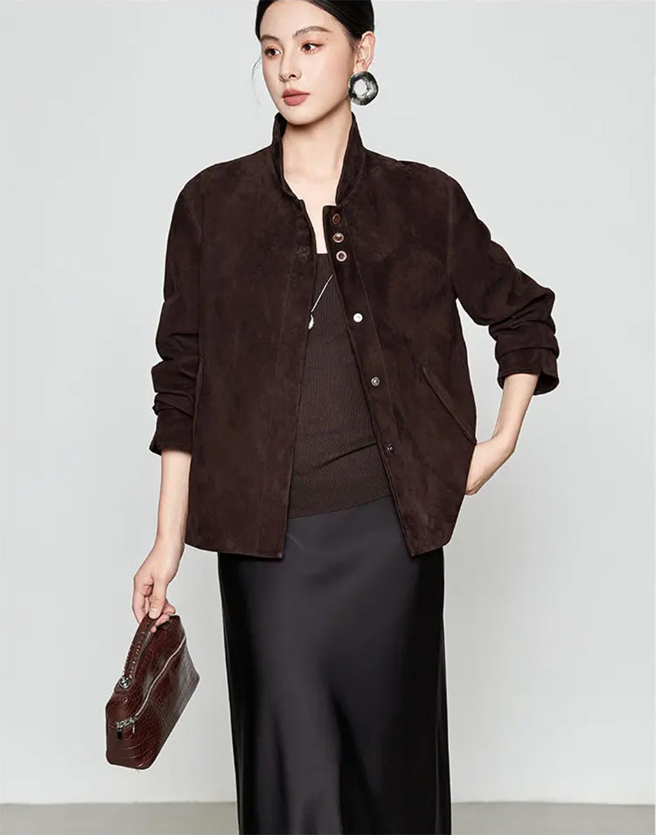 Model adjusting the hem of the Comfortable Wenge suede jacket, showcasing the hip length and side seam slit details — From Borcelleclothes.