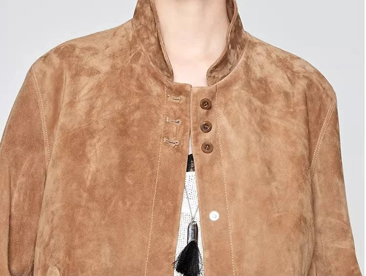 Close-up of the upper front of the Moiré Trace suede jacket, featuring the mandarin collar and trio of stitched accent buttons — From Borcelleclothes.