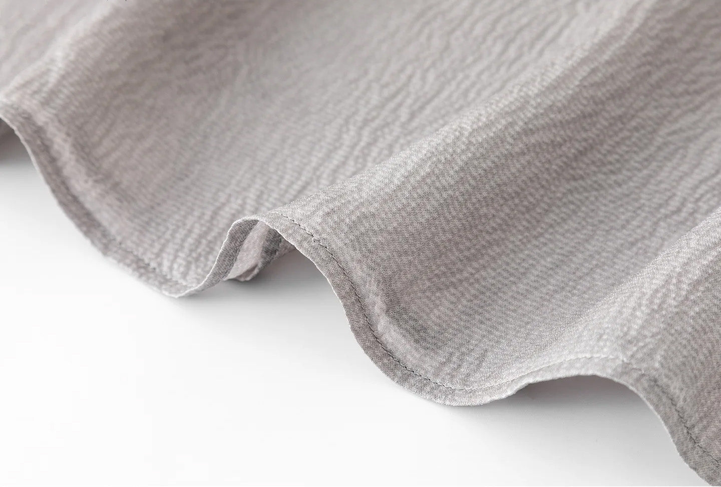 Close-up of the bottom hem and side slits on the Where Lives Nacre silk georgette blouse. — From Borcelleclothes.