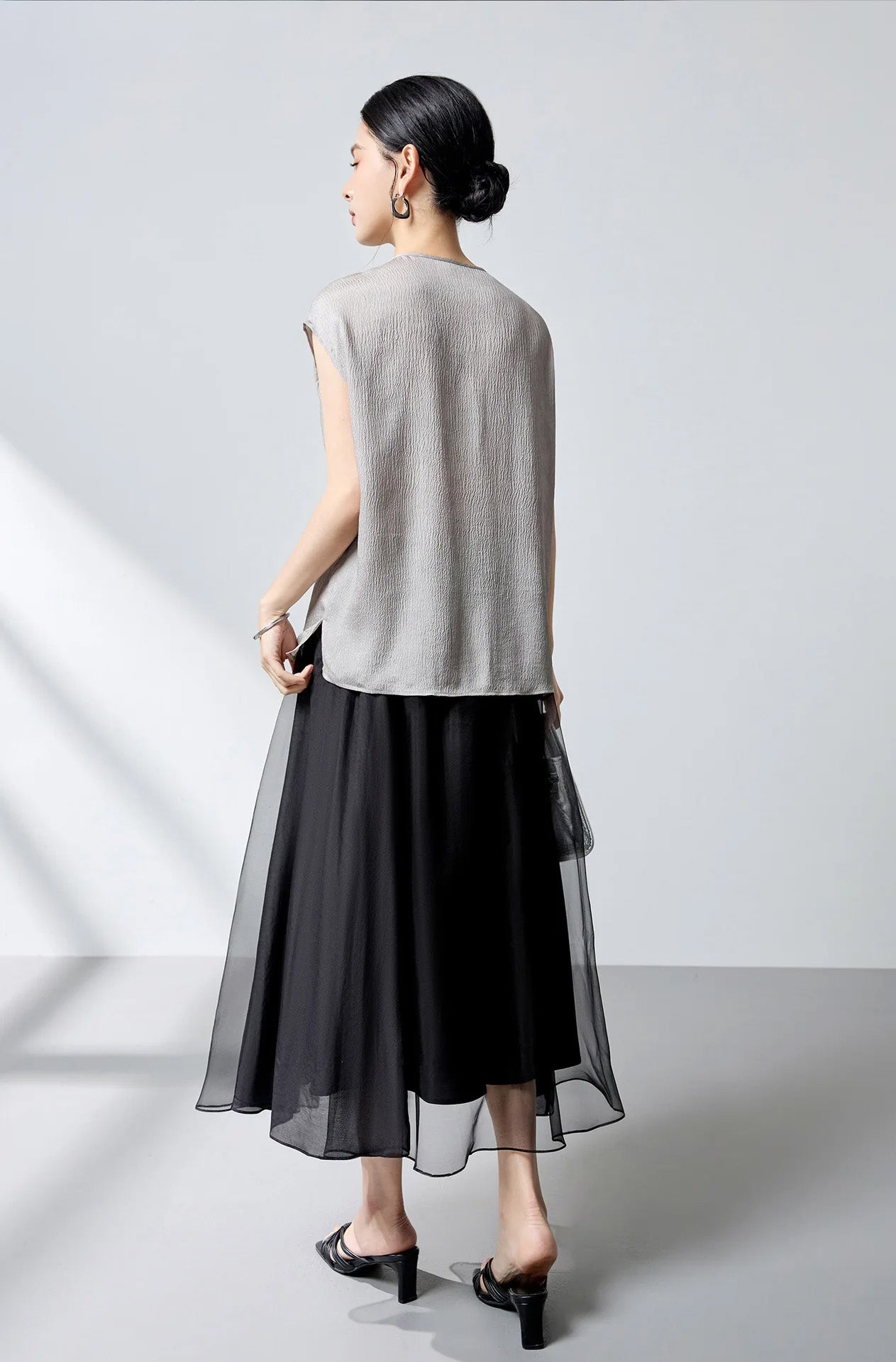 Back view of model wearing the loose-fitting silk georgette blouse in Where Lives Nacre. — From Borcelleclothes.