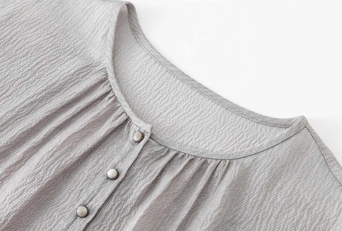 Front neckline detail of the silk blouse showing central gathers and Henley placket with cabochon buttons. — From Borcelleclothes.