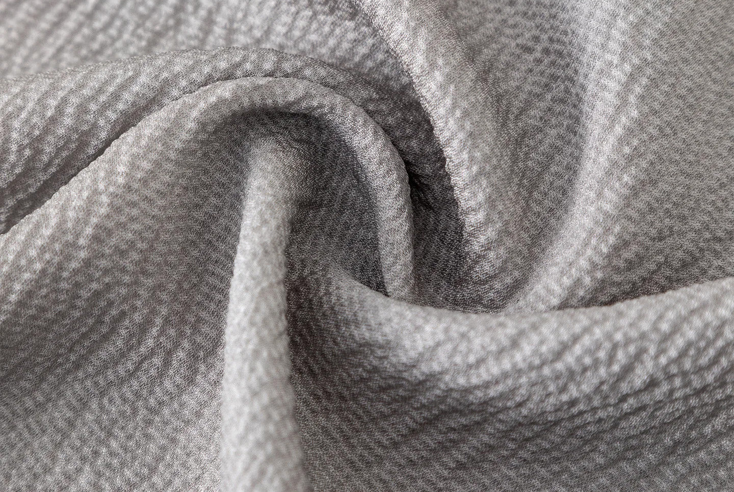 Spiral fold macro shot highlighting the sand-washed matte surface and high-twist yarn geometry. — From Borcelleclothes.