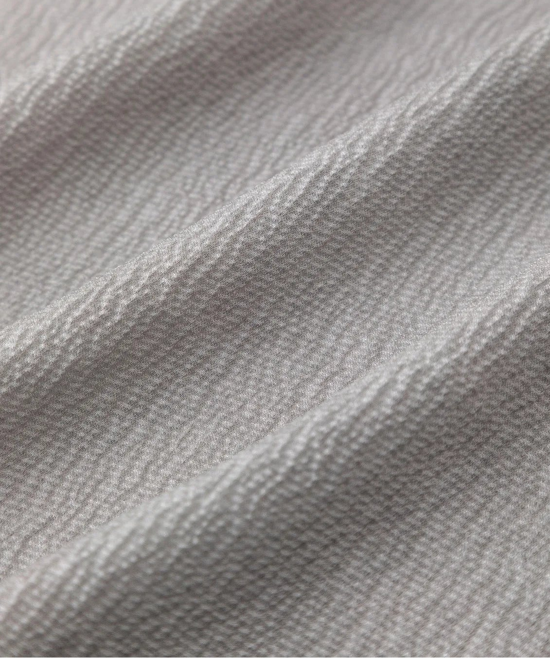 Macro view of wave-folded 14 Momme silk georgette fabric showcasing the 3D micro-puckered jacquard texture. — From Borcelleclothes.