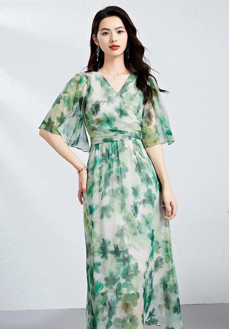 A woman posing with a hand on her hip in a Jade Breeze silk georgette dress, accentuating the asymmetrical hybrid wrap design — From Borcelleclothes.