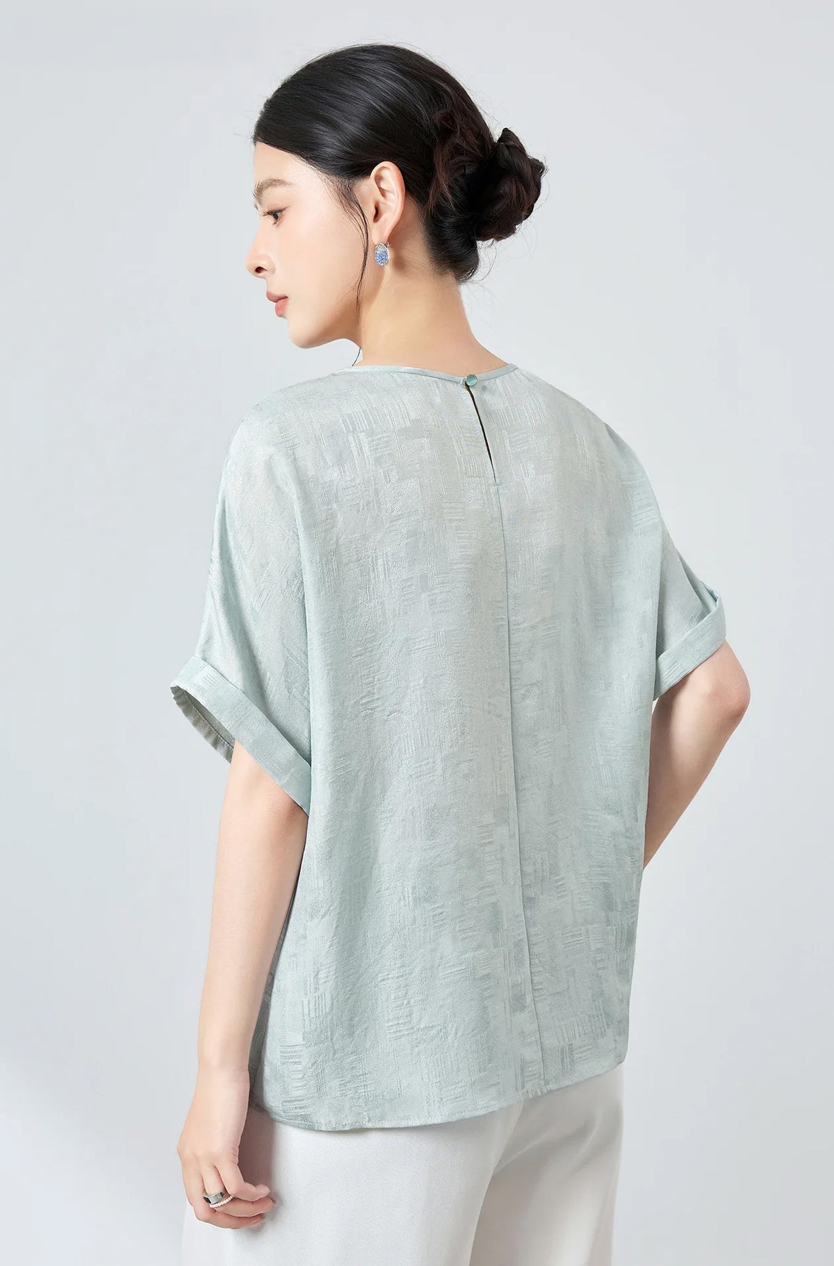 Rear view showing the smooth shoulder drape and silhouette of a women's Glacial Spring silk Sangbo jacquard blouse — From Borcelleclothes.