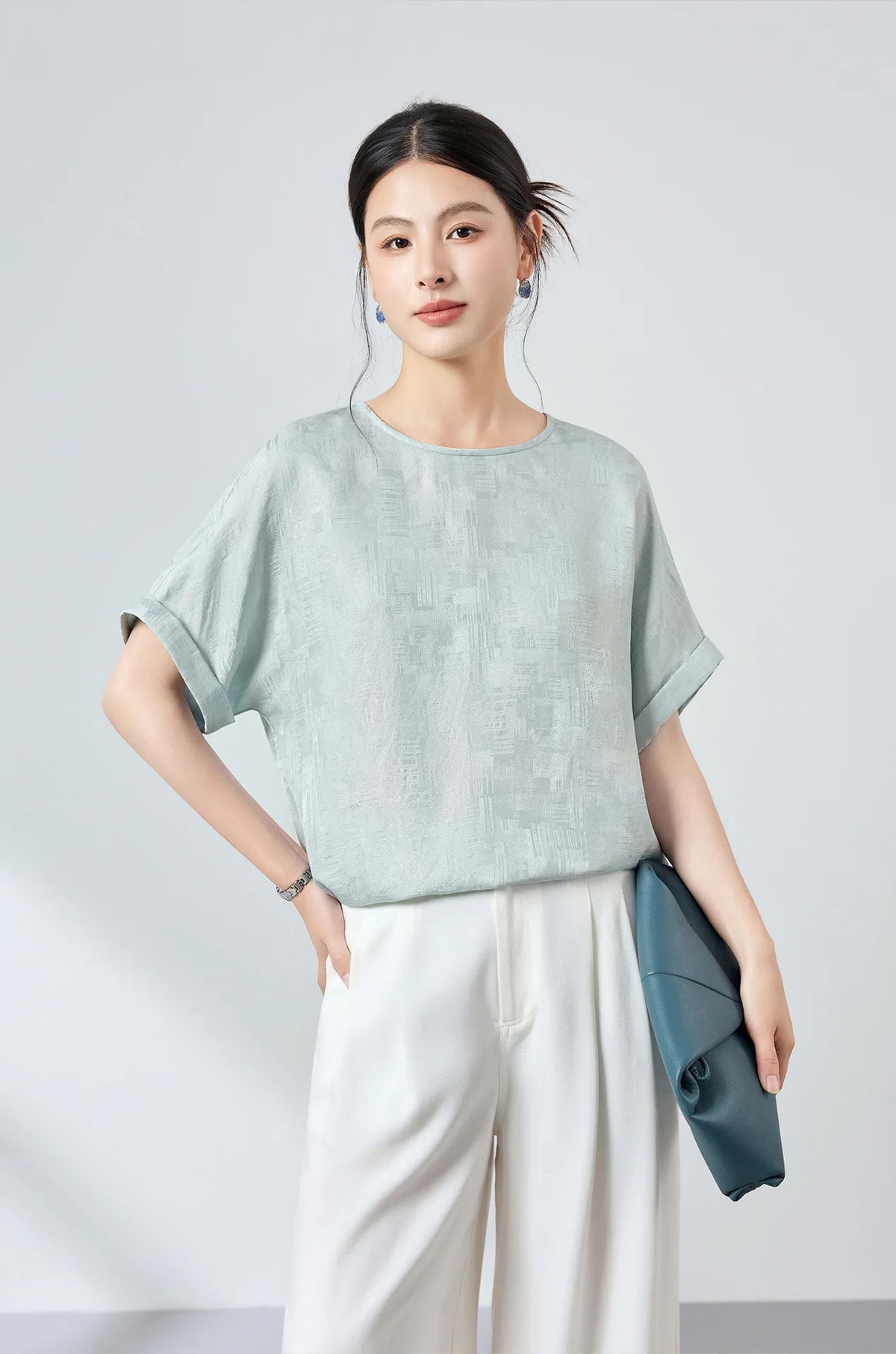 Confident pose of model with hand on hip wearing a lightweight Glacial Spring Mulberry silk Sangbo jacquard blouse — From Borcelleclothes.