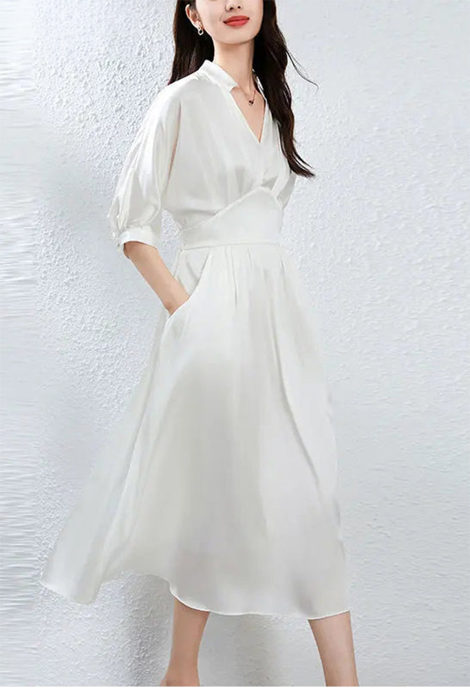 Woman walking gracefully in the Hot Ice dress, capturing the light on the silk — From Borcelleclothes.