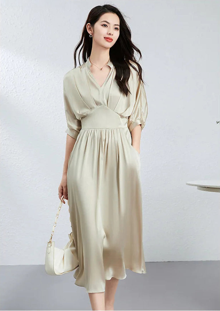 Woman with a hand in her deep curved slash pocket, holding a stylish bag — From Borcelleclothes.