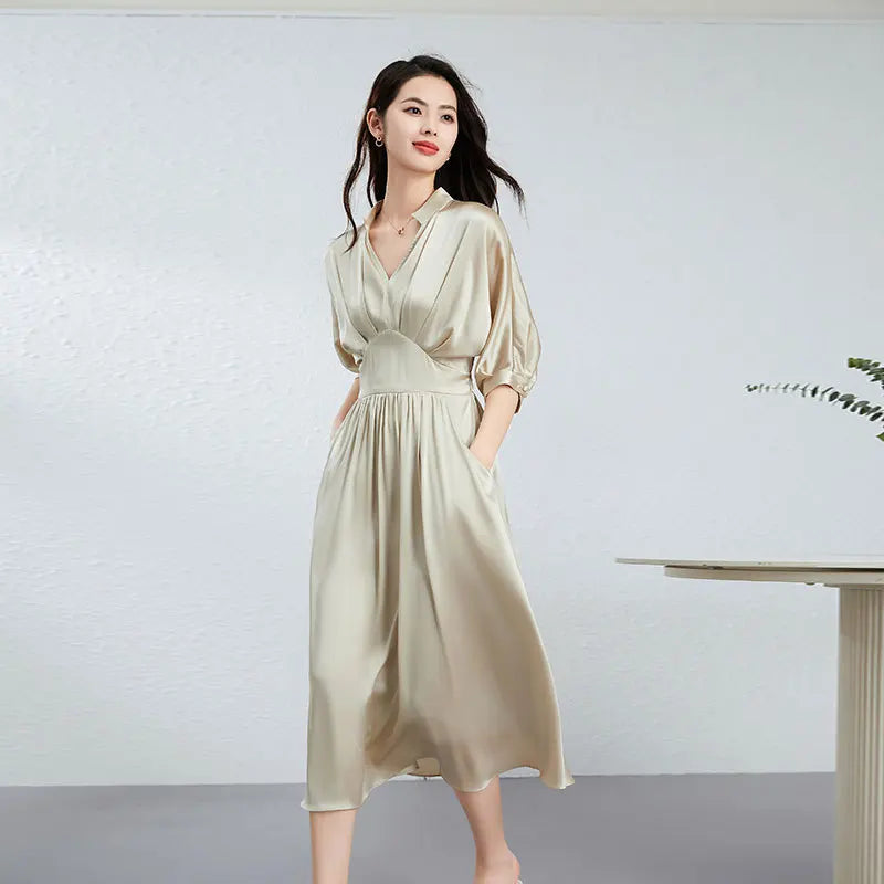 A midi-length Mulberry silk satin dress in Taste of Champagne, with a stand-up collar, V-neckline, and elegant pleated waist detail. — From Borcelleclothes.
