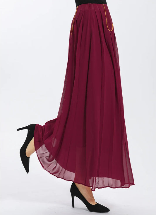 Side view on model with a bent leg, revealing the semi-sheer georgette panel and the bold line of contrast gold piping — From Borcelleclothes.
