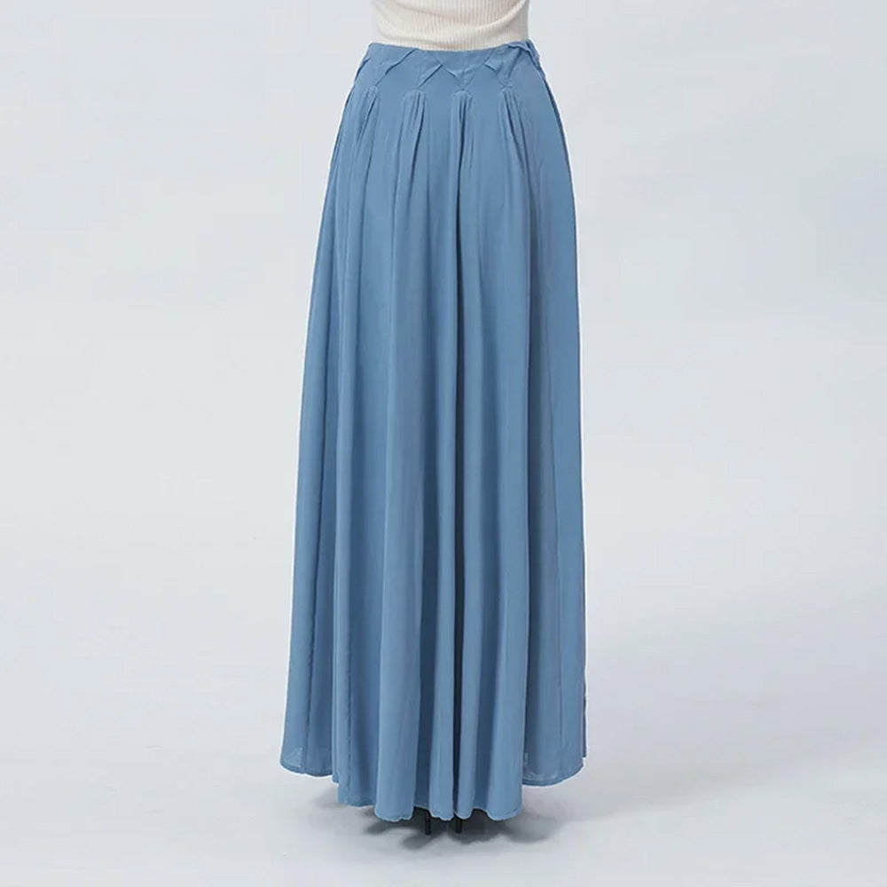 Mid-length back view of the model, illustrating the seamless integration of the delicately gathered, sculptural arched panels directly below the travertine-inspired waist tiers. — From Borcelleclothes.