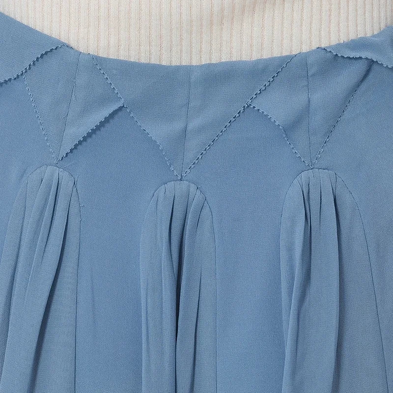 Detailed close-up of the innovative, waist-defining top edge, showing the overlapping two-tier facing composed of structured geometric triangles framed by delicate trim. — From Borcelleclothes.