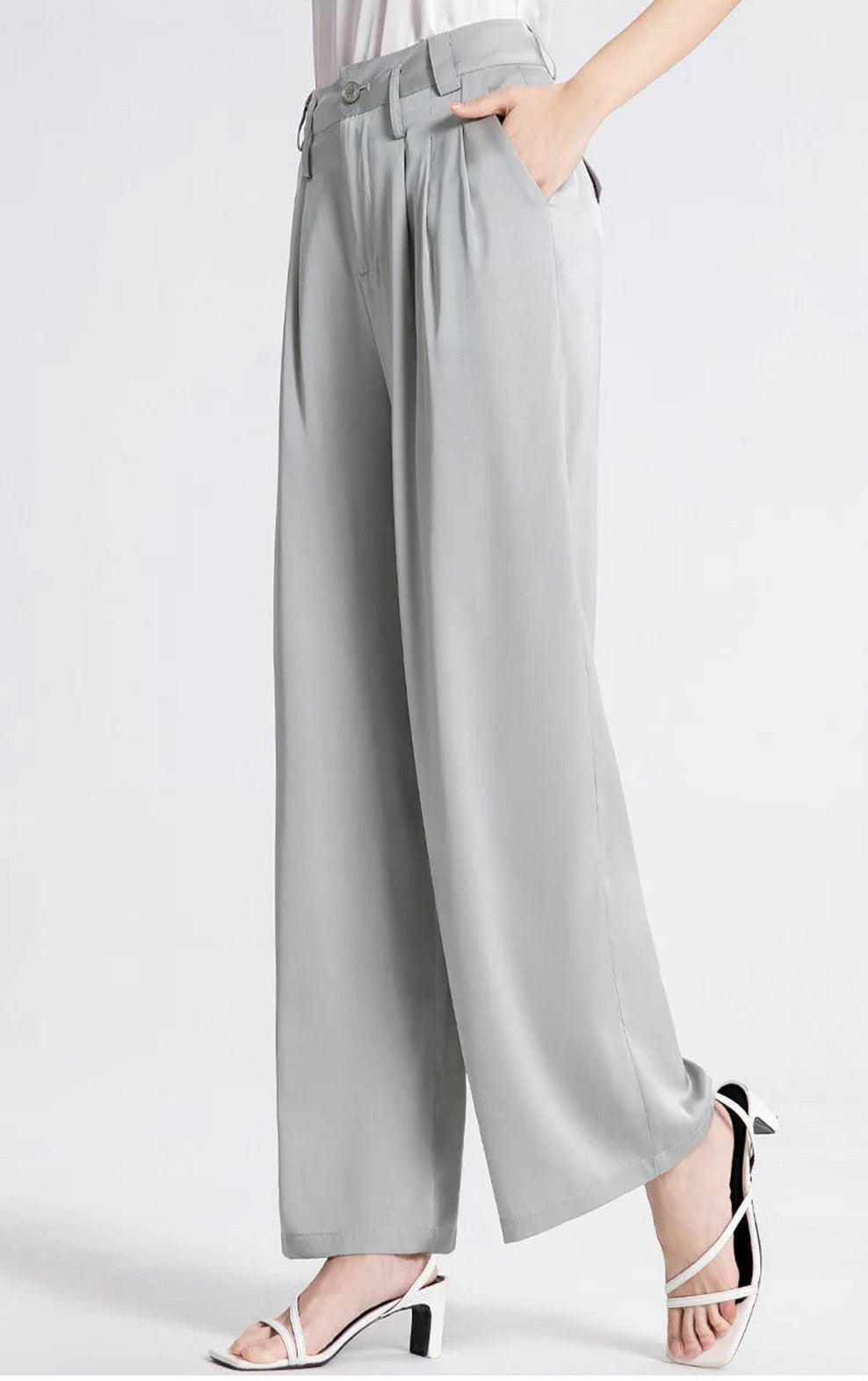 Side view of a model with her hand in the pocket of gray silk trousers. — Borcelleclothes.