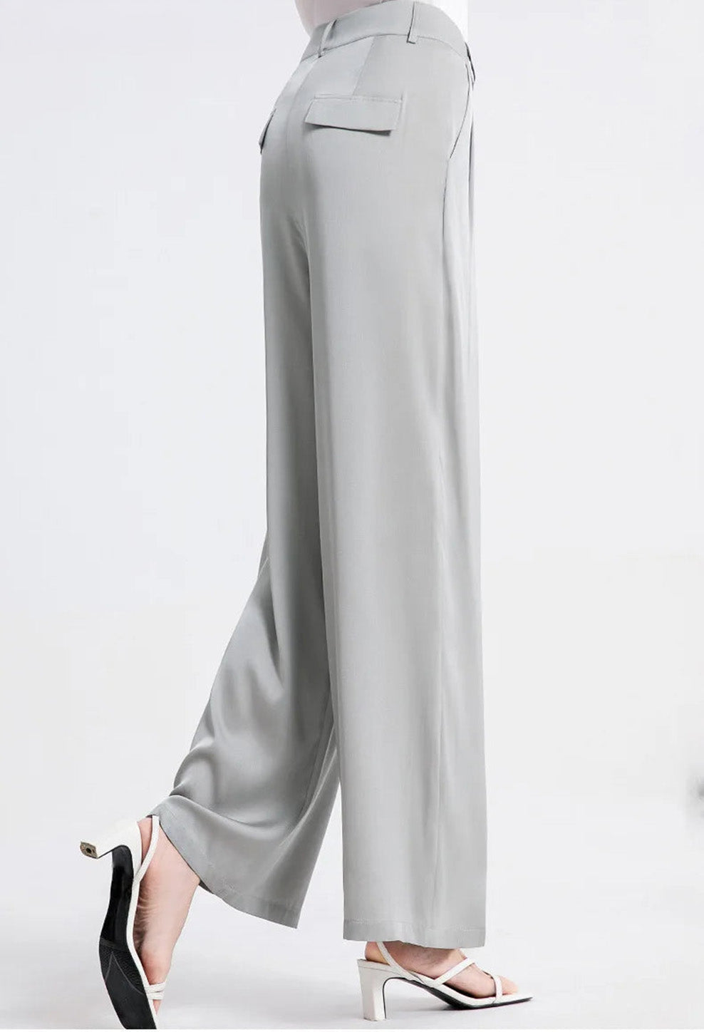 Side view of a model posing in gray six-pleats Mulberry silk trousers. — Borcelleclothes.