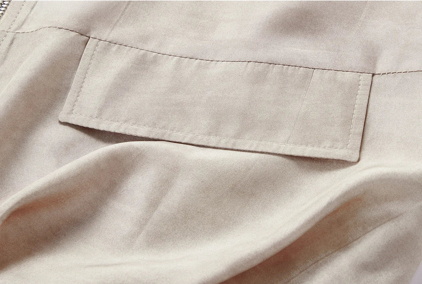 Macro shot of the decorative flap detail integrated into the lower panel in Whispering Wind — From Borcelleclothes.