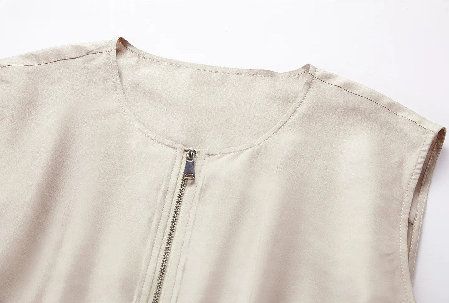 Upper torso view highlighting the collarless round neckline of the sleeveless silk blouson jacket in Whispering Wind — From Borcelleclothes.