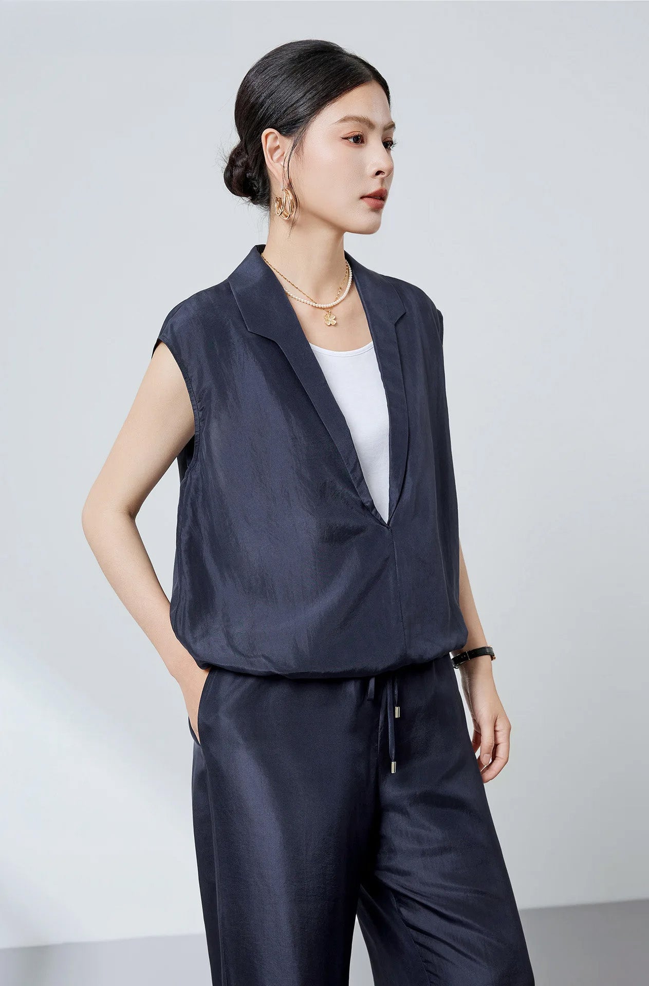 Model in Blueprint stepped collar silk blouse and matching silk trousers turned slightly to the side — From Borcelleclothes.