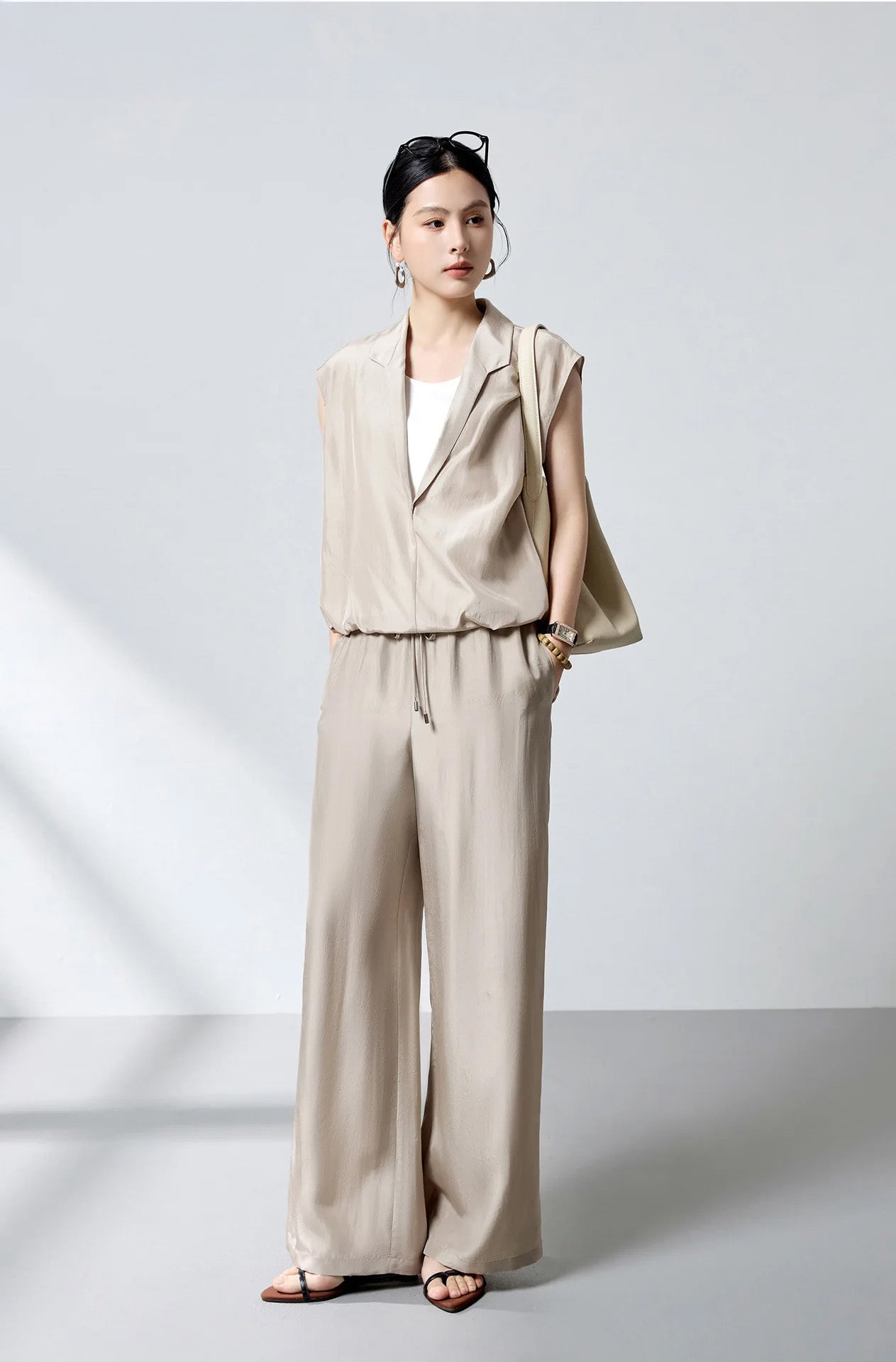 Model wearing the Morning Draft layered silk blouse with an elongated stepped shawl collar and shoulder bag — From Borcelleclothes.