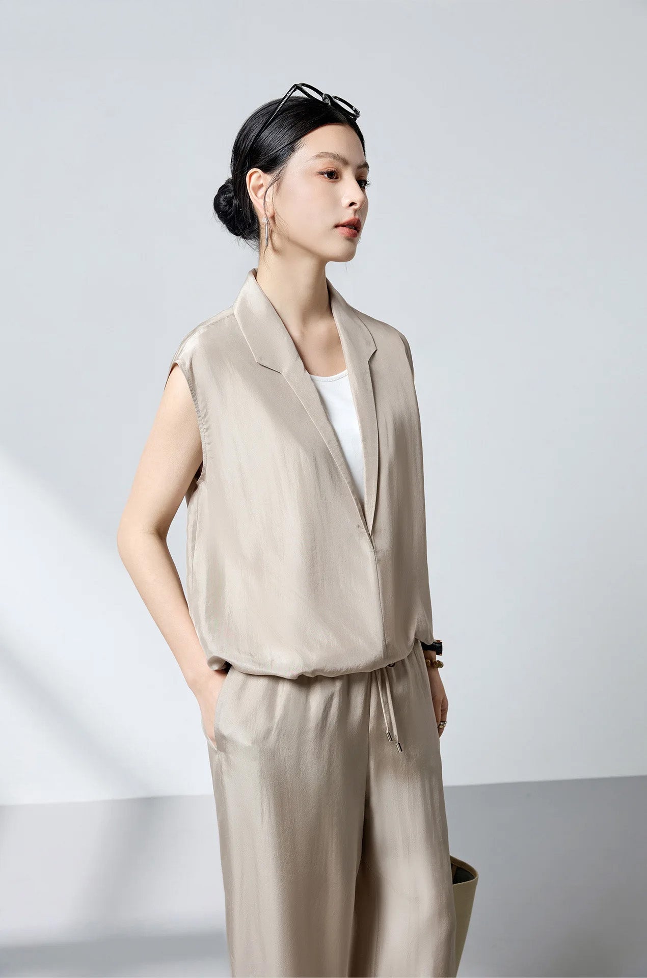 Model in Morning Draft stepped collar silk blouse turned slightly to the side holding a leather bag — From Borcelleclothes.