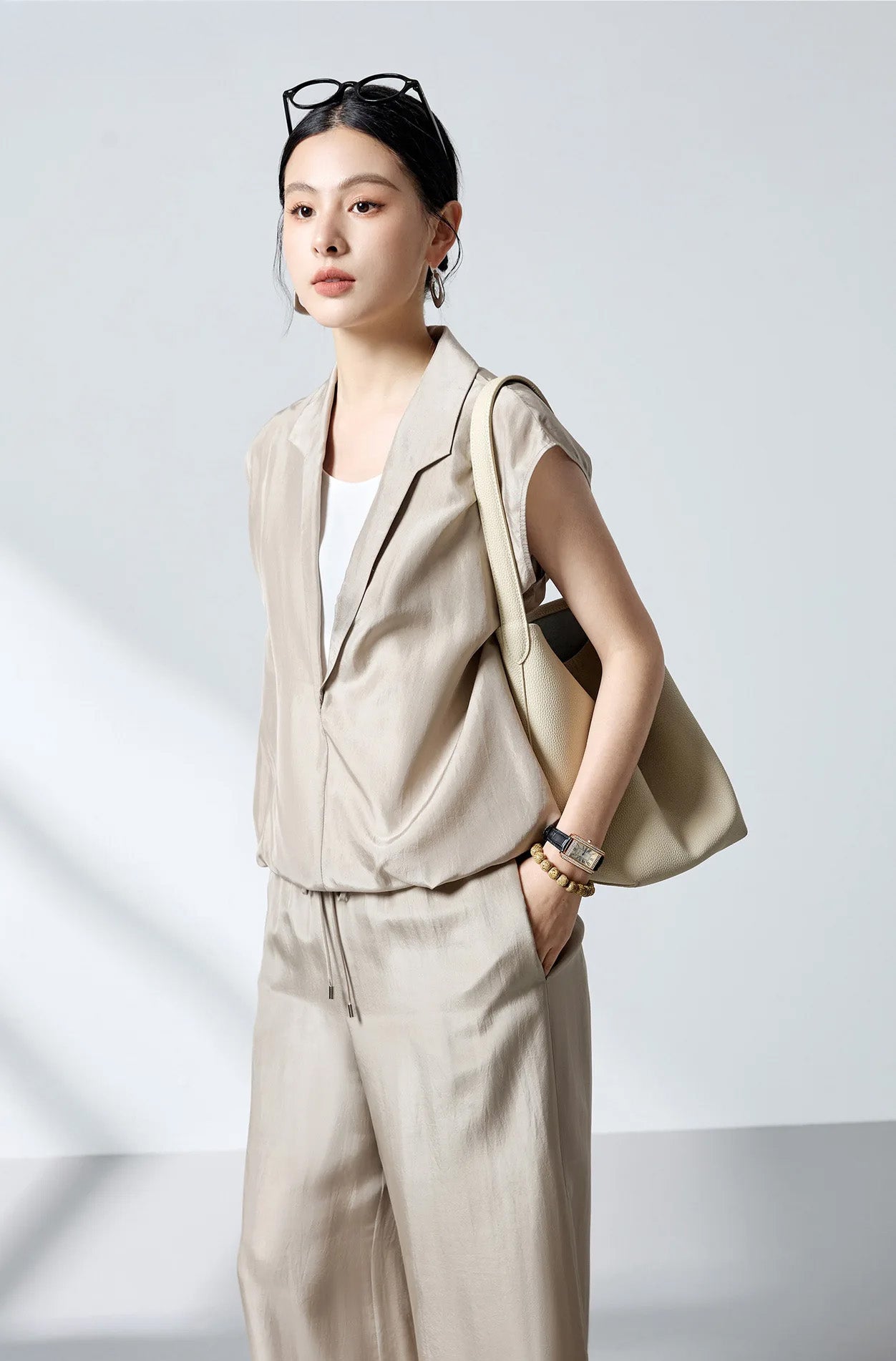 Three-quarter side view of model wearing the stepped collar silk blouse in Morning Draft with shoulder bag — From Borcelleclothes.