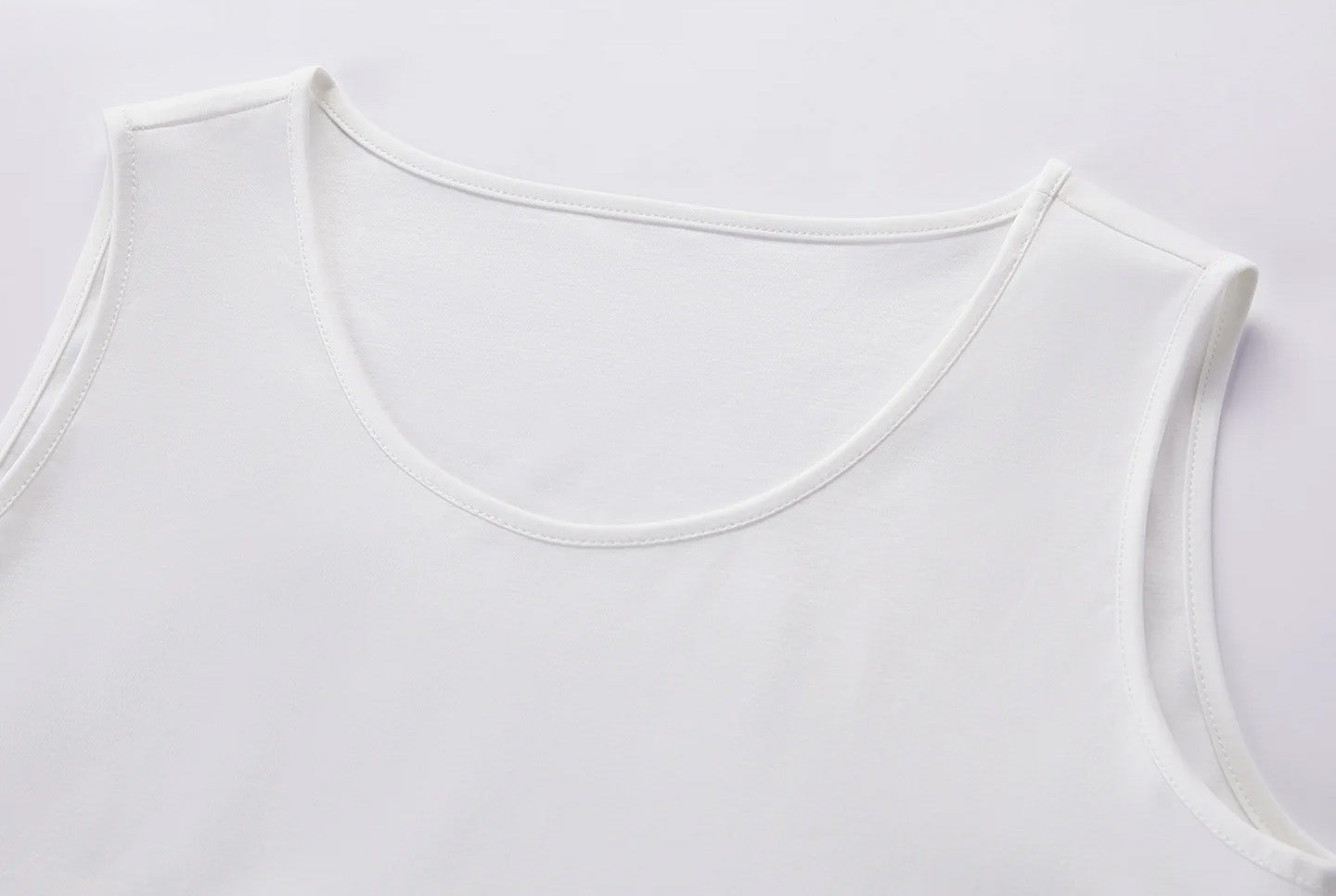 Structural detail of the breathable white inner tank top joined at the elasticated hemline — From Borcelleclothes.