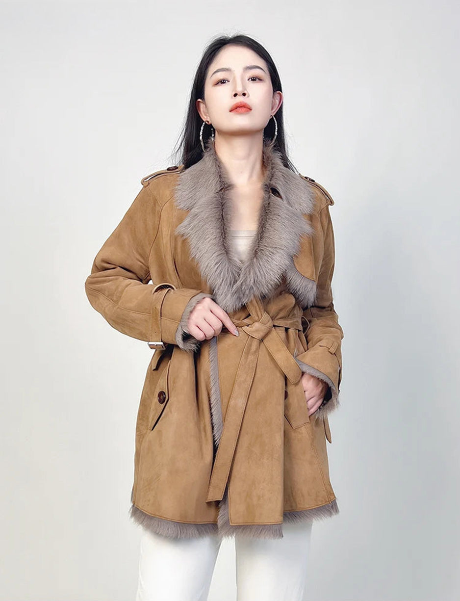 Model gently touching the belt of the goatskin coat — From Borcelleclothes.