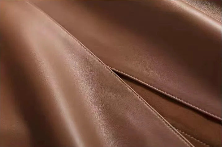 Detailed view of the asymmetric front seam slit on a sheepskin midi skirt in Bay Grace — From Borcelleclothes.