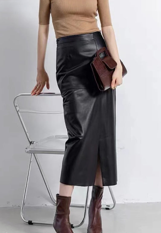Model wearing a women's straight sheepskin midi skirt with an asymmetric front slit in Dark Horse, holding a handbag — From Borcelleclothes.